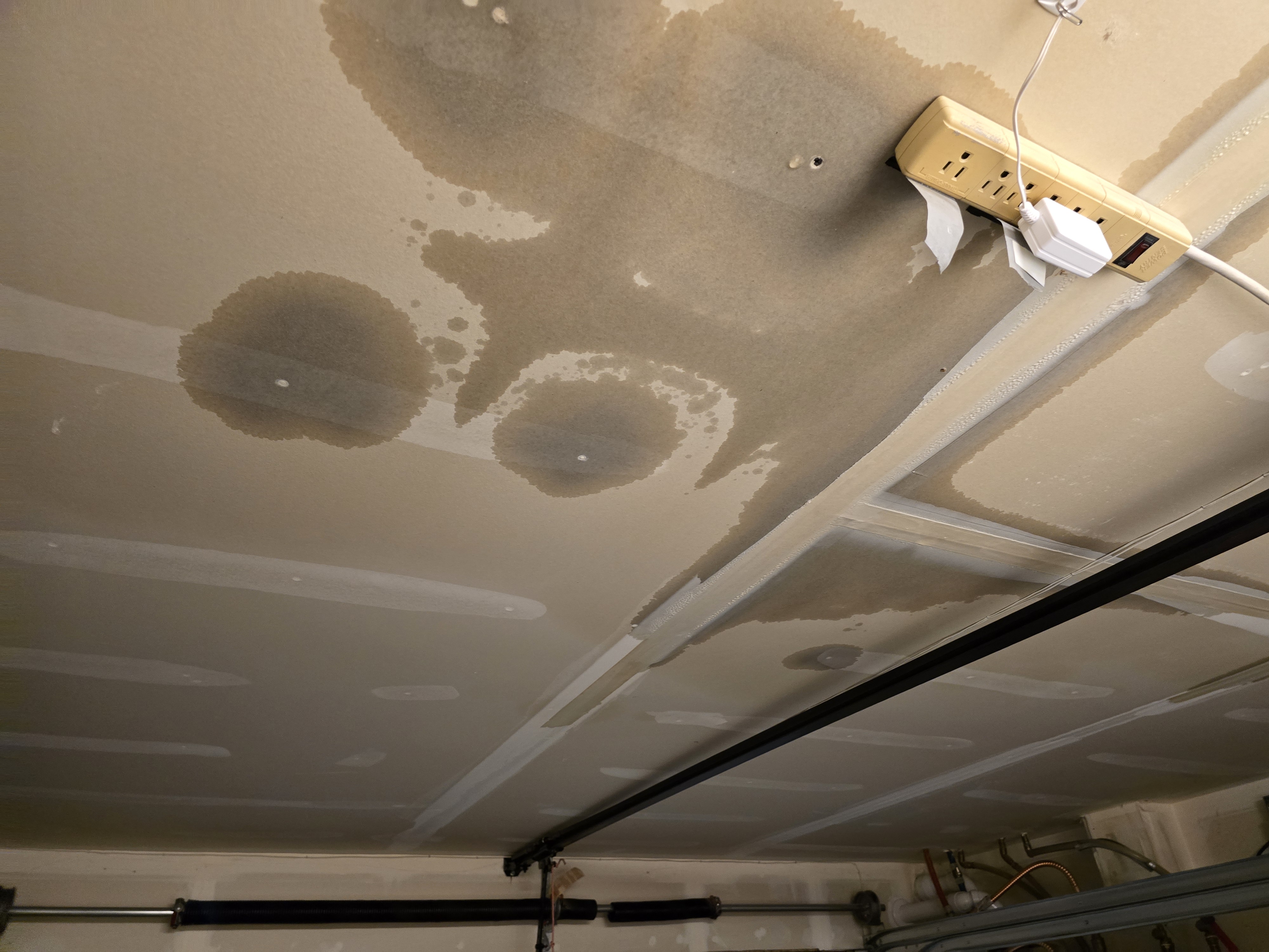 Ceiling showing extensive water stains and damage from roof leak in King County home